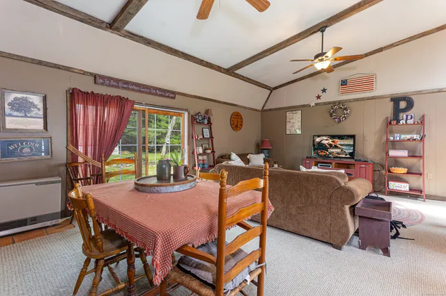 a dining room with furniture and a large window