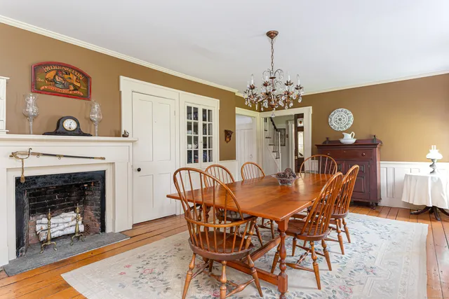 a view of a dining room with furniture wooden floor and a fireplace
