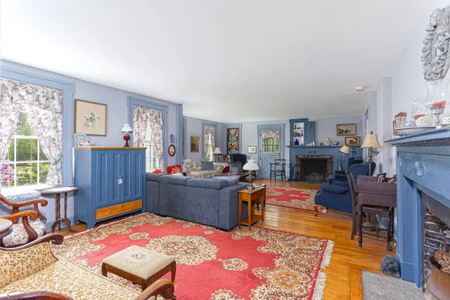 a living room with furniture and a dining table with fireplace