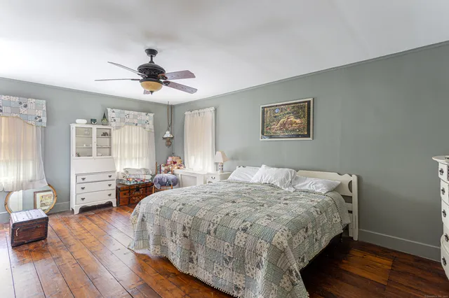 a bed sitting in a bedroom and view of living room