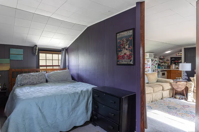 a bedroom with a bed and dresser with mirror