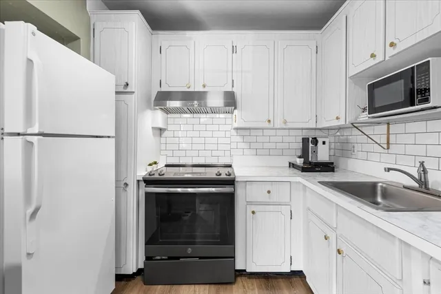 a kitchen with white cabinets and white appliances