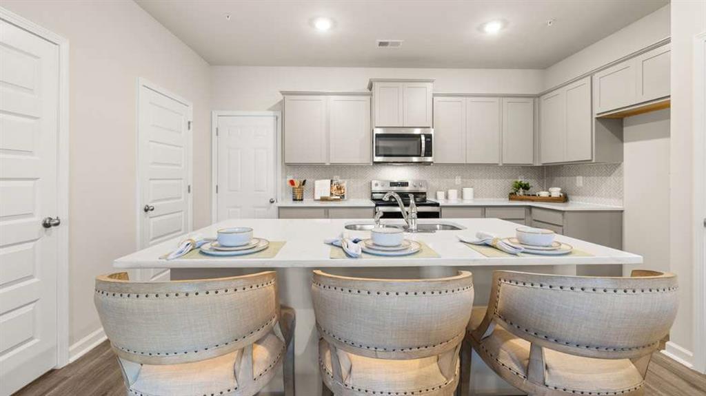 416 Reflection Drive Stockbridge, GA 30281 - Photo 13 of 66 a kitchen with stainless steel appliances granite countertop a table and chairs