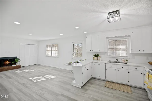 a kitchen with white cabinets and window