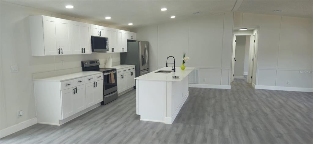 5641 South Butan Point Homosassa, FL 34446 - Photo 3 of 14 a kitchen with cabinets a sink and wooden floor