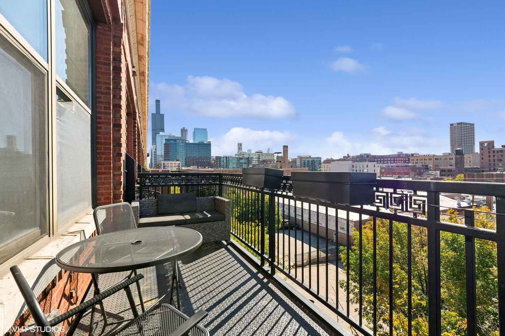 1040 West Adams Street, Unit 473 Chicago, IL 60607 - Photo 13 of 19 a view of a balcony with a table and chairs