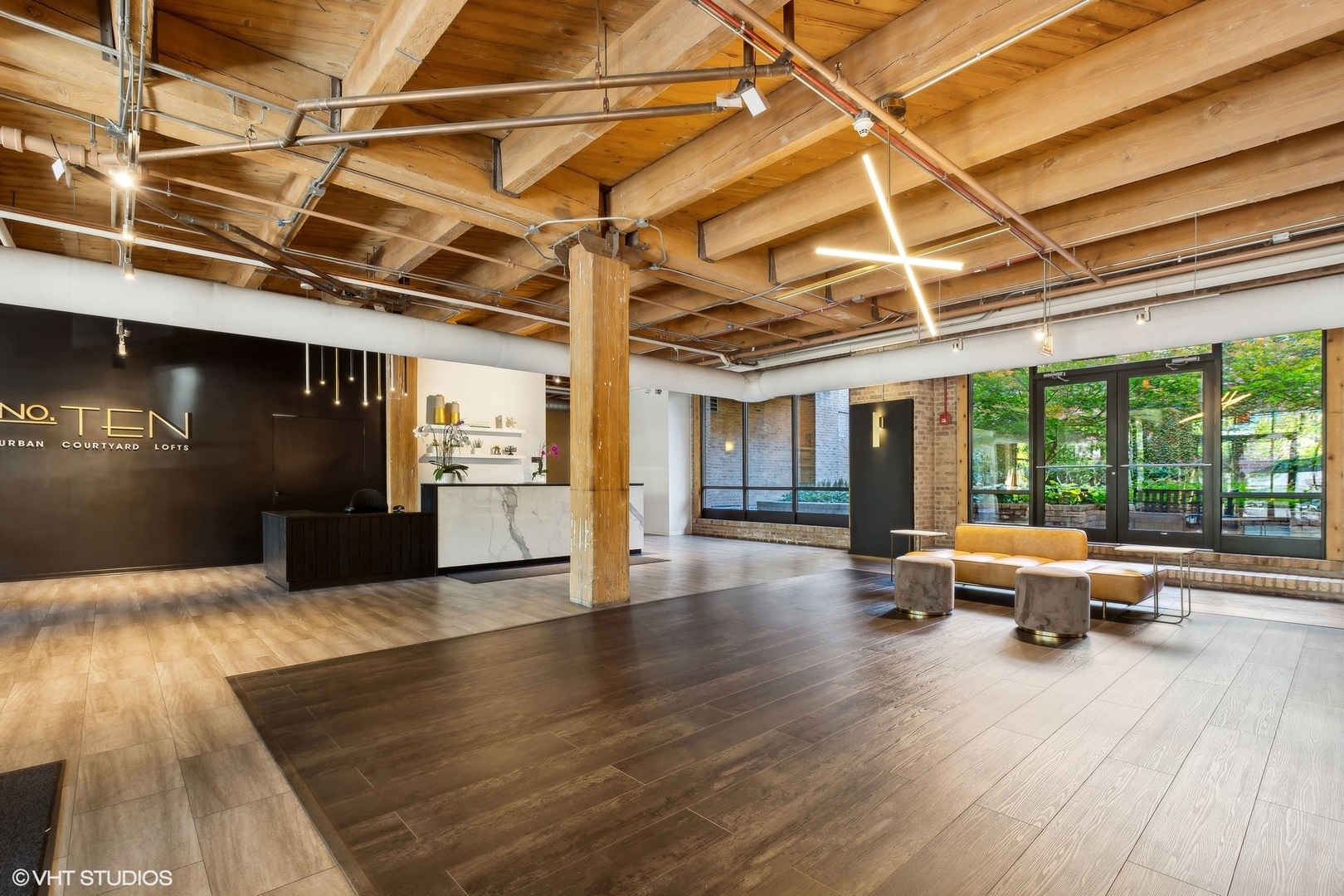 1040 West Adams Street, Unit 473 Chicago, IL 60607 - Photo 2 of 19 a view of a hall with wooden floor and a glass door