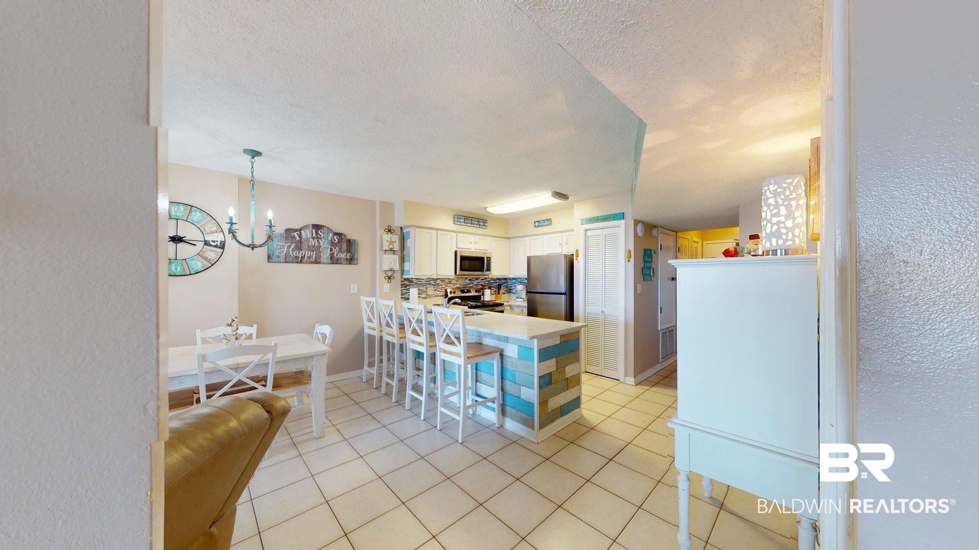 645 Plantation Road, Unit 6503 Gulf Shores, AL 36542 - Photo 42 of 53 Kitchen featuring a peninsula, a textured ceiling, light countertops, light tile patterned floors, and a chandelier