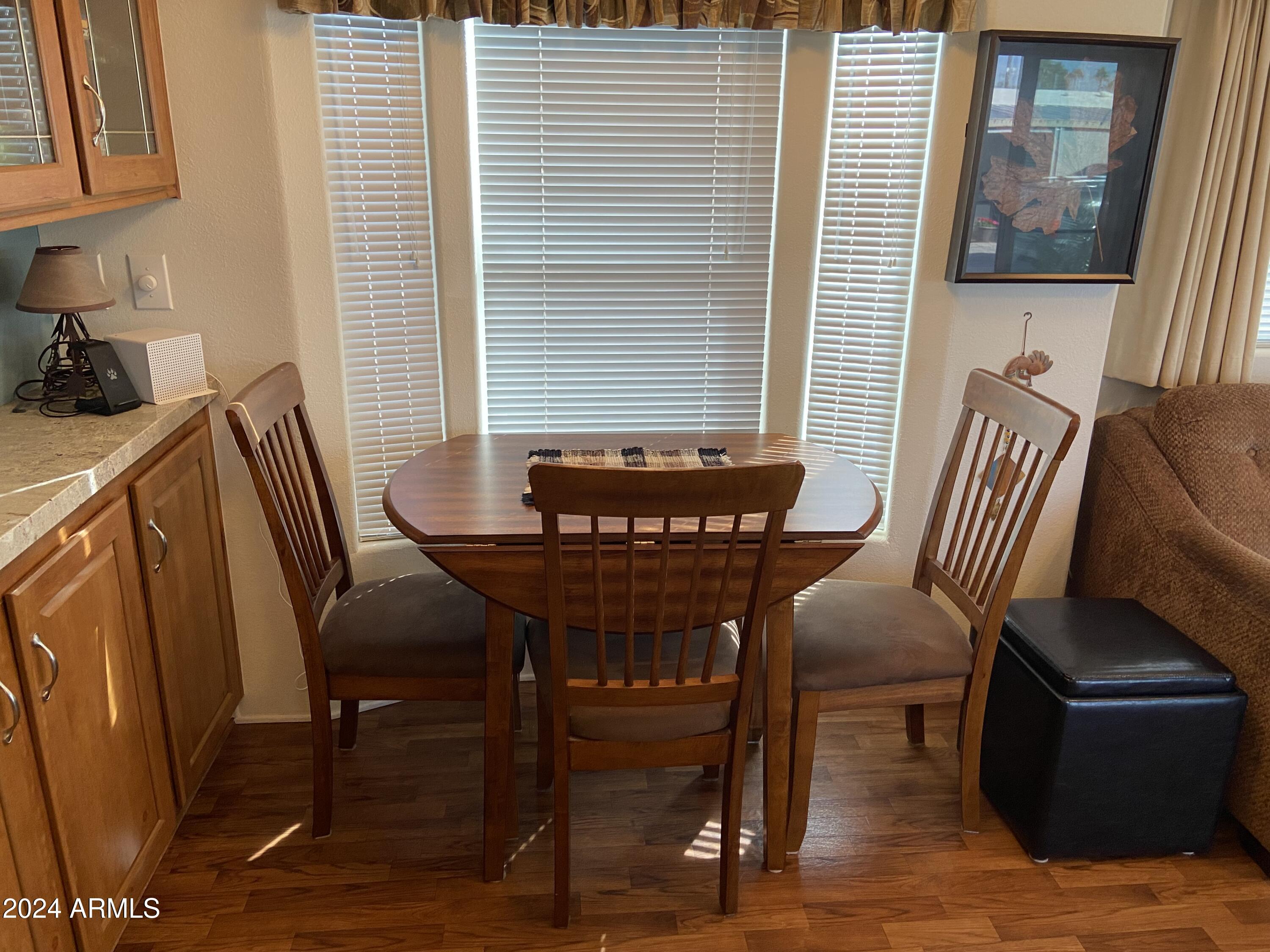 1415 South Havasupai Drive, Unit 415 Apache Junction, AZ 85119 - Photo 13 of 28 a view of a dining room with furniture window and wooden floor