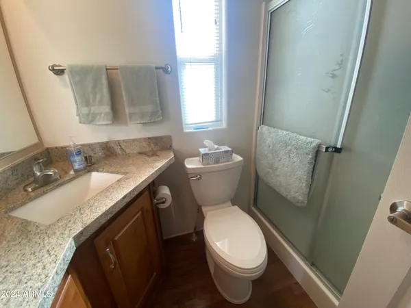 a bathroom with a granite countertop sink toilet and mirror
