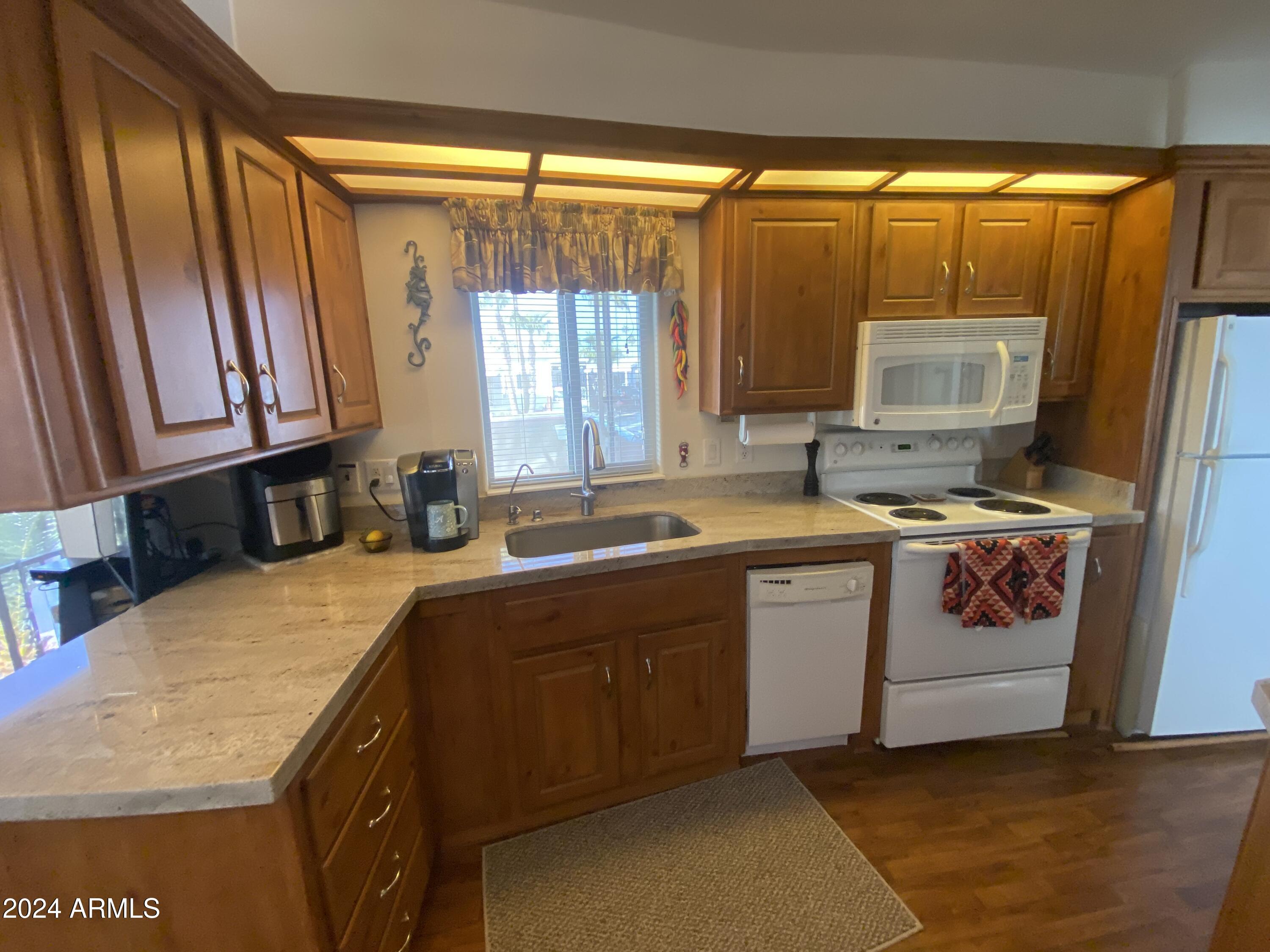 1415 South Havasupai Drive, Unit 415 Apache Junction, AZ 85119 - Photo 9 of 28 a kitchen with stainless steel appliances a stove a sink and a microwave