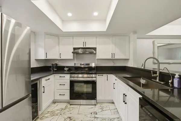 a kitchen with stainless steel appliances granite countertop a sink stove and refrigerator