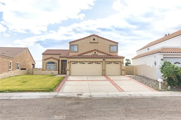 a view of a white house with a big yard and large trees