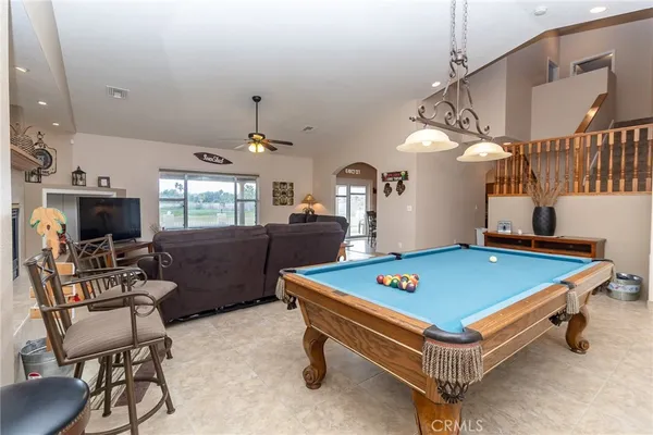 a dining room with wooden floor a chandelier a wooden table and chairs
