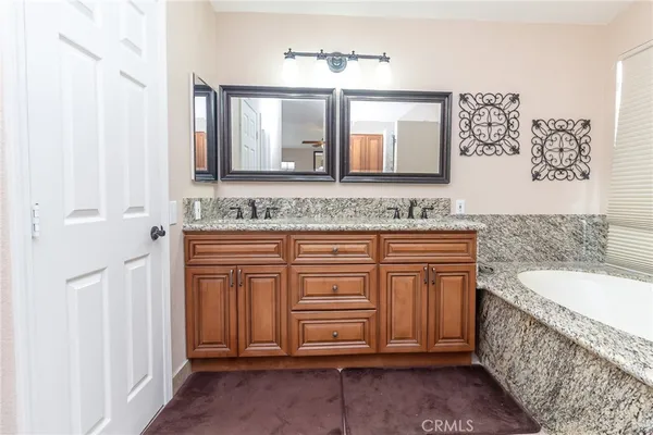 a bathroom with a granite countertop sink and a toilet
