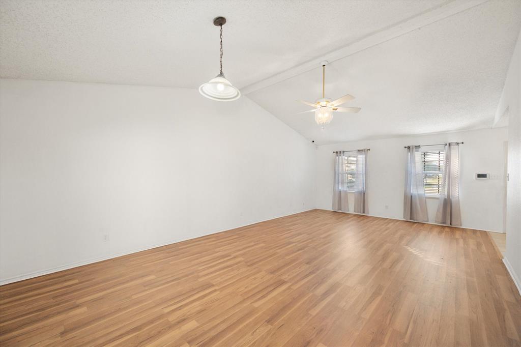 7308 Red Osier Road Dallas, TX 75249 - Photo 11 of 27 a view of empty room with wooden floor and ceiling fan