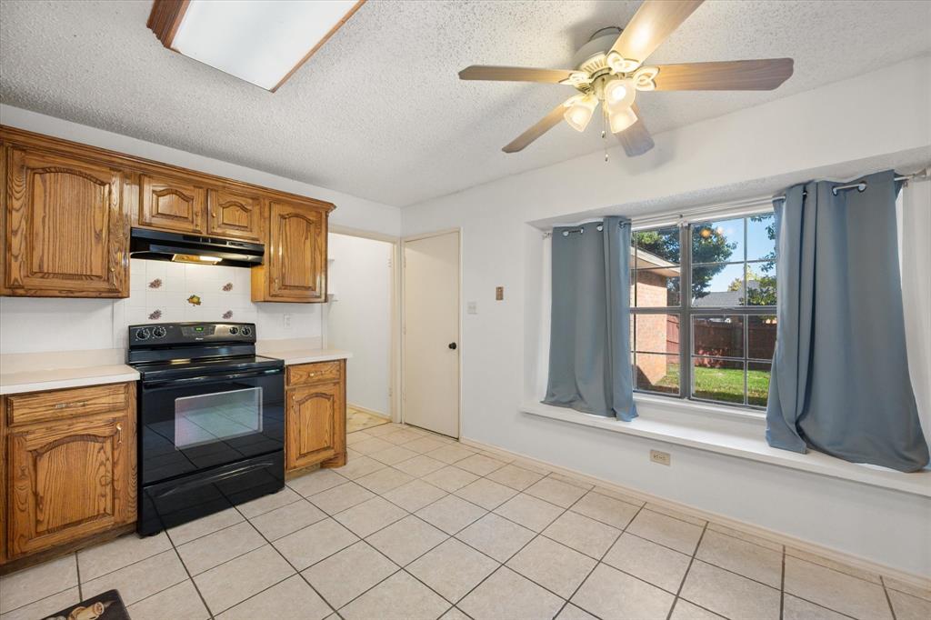 7308 Red Osier Road Dallas, TX 75249 - Photo 13 of 27 a kitchen with stainless steel appliances granite countertop a stove a sink and a refrigerator with cabinets