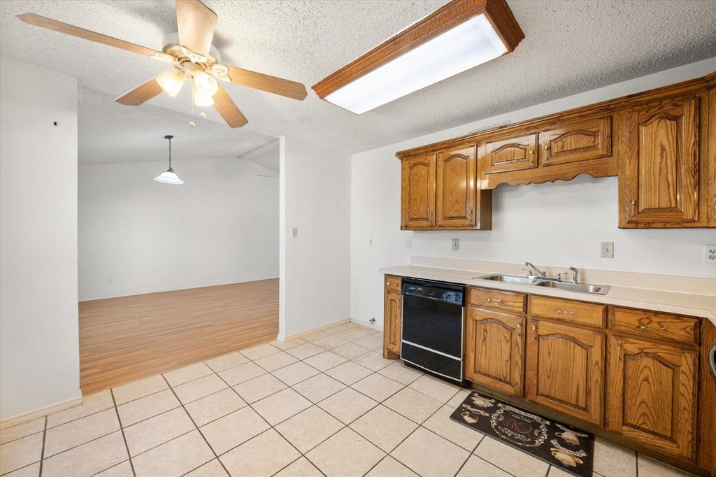 7308 Red Osier Road Dallas, TX 75249 - Photo 15 of 27 a kitchen with stainless steel appliances a sink cabinets and wooden floor