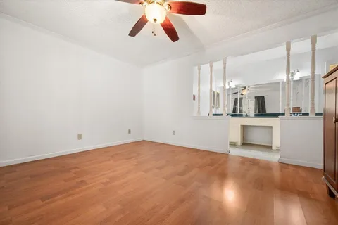 an empty room with kitchen and view of kitchen
