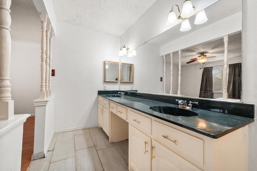 7308 Red Osier Road Dallas, TX 75249 - Photo 18 of 27 a spacious bathroom with a granite countertop sink a mirror and a