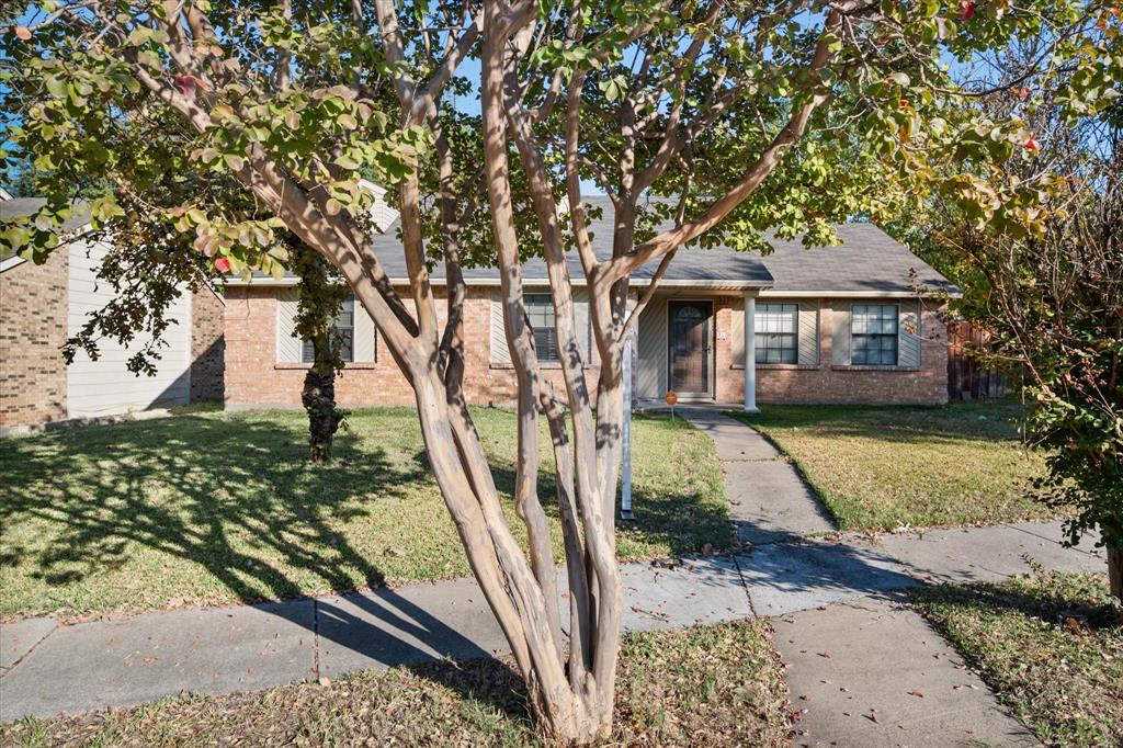 7308 Red Osier Road Dallas, TX 75249 - Photo 2 of 27 a front view of a house with garden