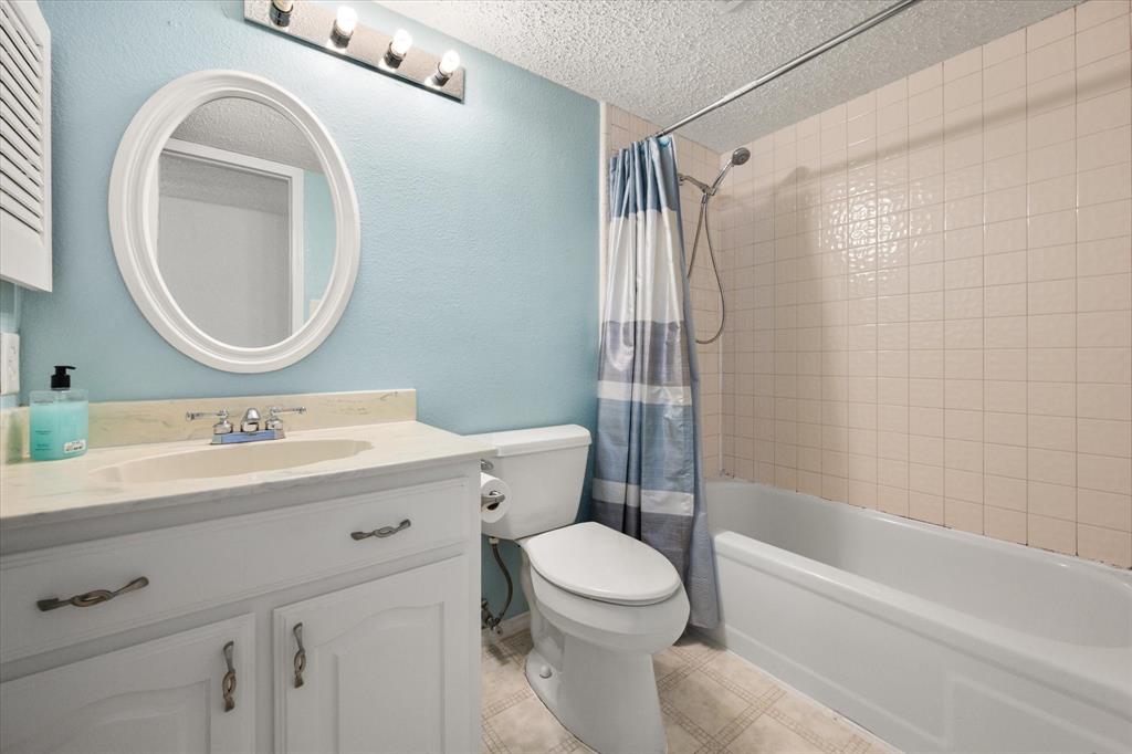 7308 Red Osier Road Dallas, TX 75249 - Photo 21 of 27 a bathroom with a sink a toilet and a mirror
