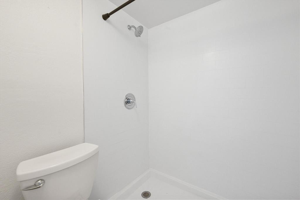 7308 Red Osier Road Dallas, TX 75249 - Photo 23 of 27 a white toilet sitting next to a shower