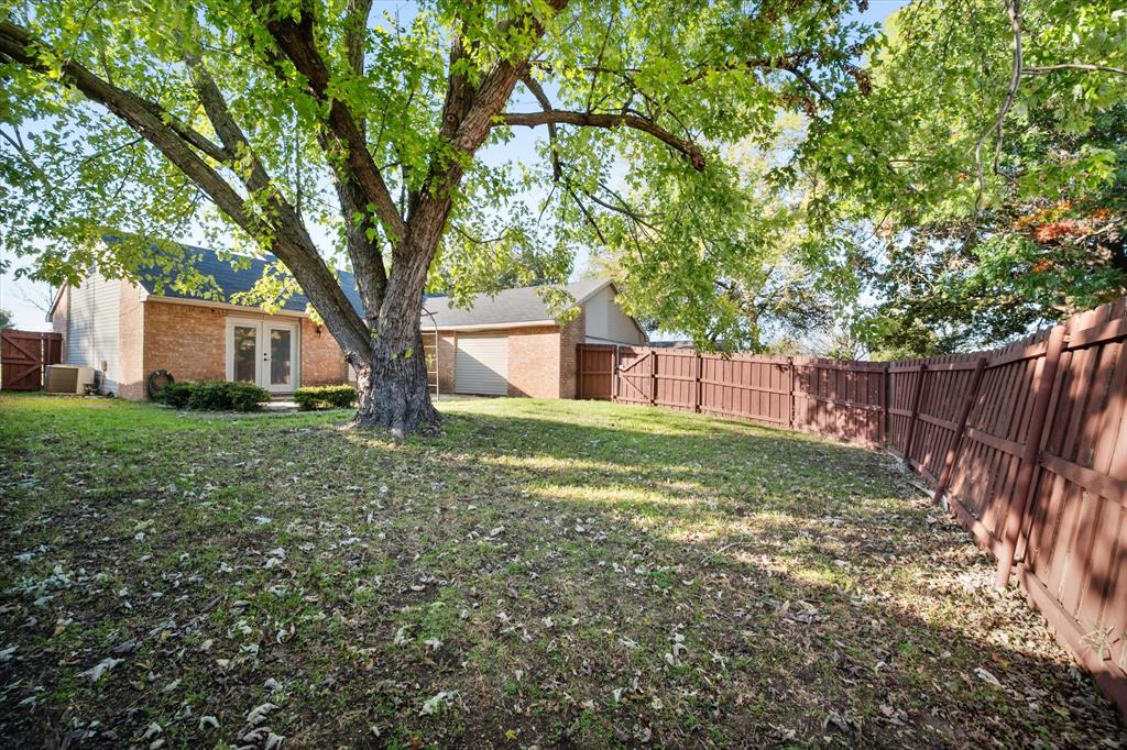 7308 Red Osier Road Dallas, TX 75249 - Photo 26 of 27 a view of a yard with large tree and wooden fence