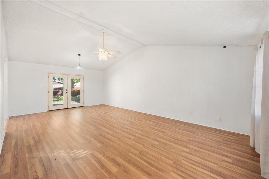 7308 Red Osier Road Dallas, TX 75249 - Photo 7 of 27 a view of an empty room with window and wooden floor