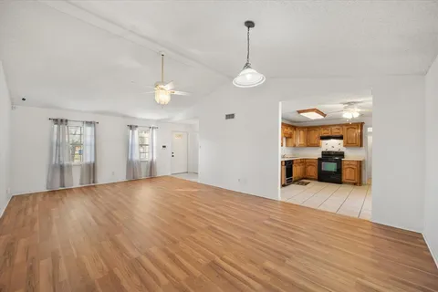 a view of empty room with wooden floor and window