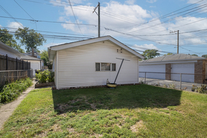 5705 West Higgins Avenue, Unit 1 Chicago, IL 60630 - Photo 12 of 12 a backyard of a house with plants and a large tree