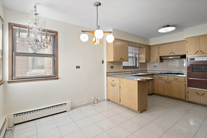 5705 West Higgins Avenue, Unit 1 Chicago, IL 60630 - Photo 5 of 12 a kitchen with cabinets a sink stainless steel appliances and window