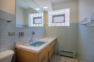 5705 West Higgins Avenue, Unit 1 Chicago, IL 60630 - Photo 10 of 12 a bathroom with a sink a toilet and a mirror