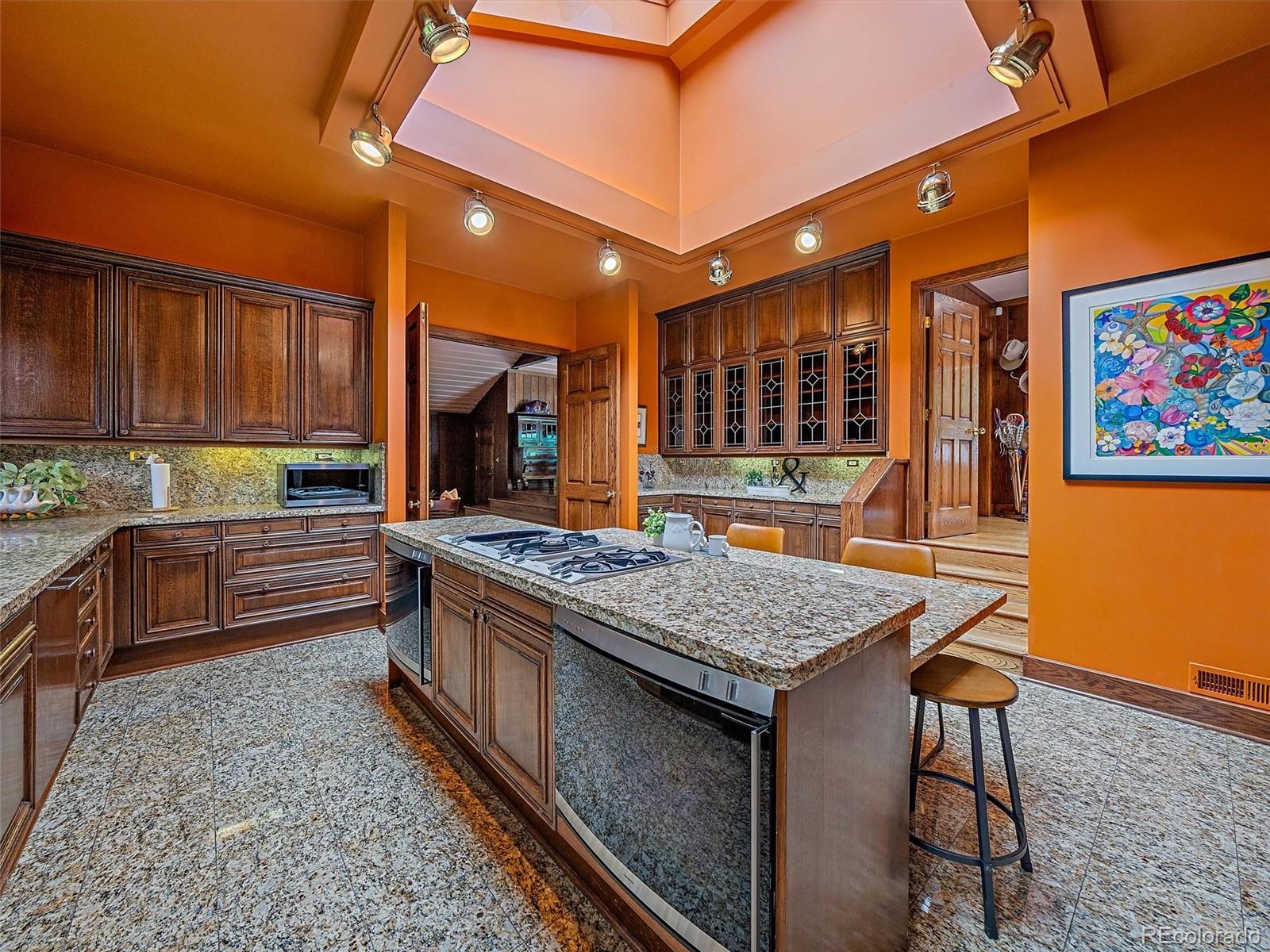 32453 Upper Bear Creek Road Evergreen, CO 80439 - Photo 15 of 48 a kitchen with stainless steel appliances granite countertop a stove a sink and a microwave