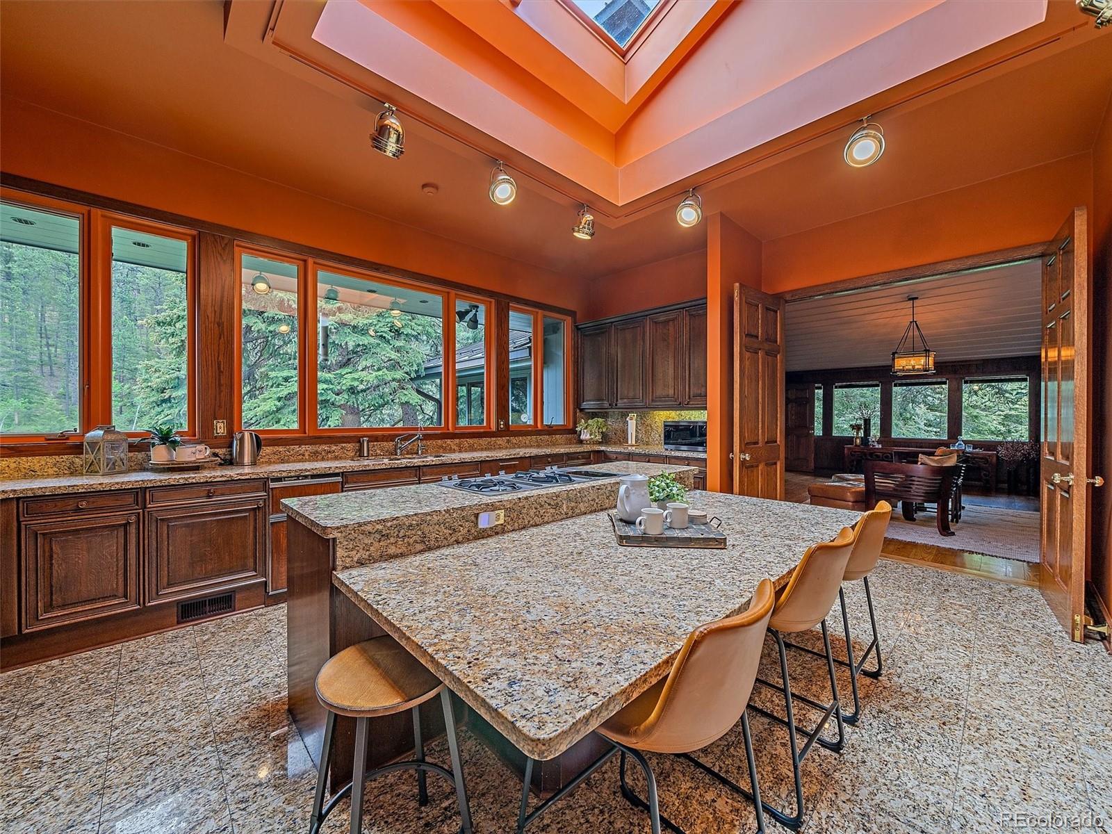 32453 Upper Bear Creek Road Evergreen, CO 80439 - Photo 16 of 48 a kitchen with a stove a sink and chairs