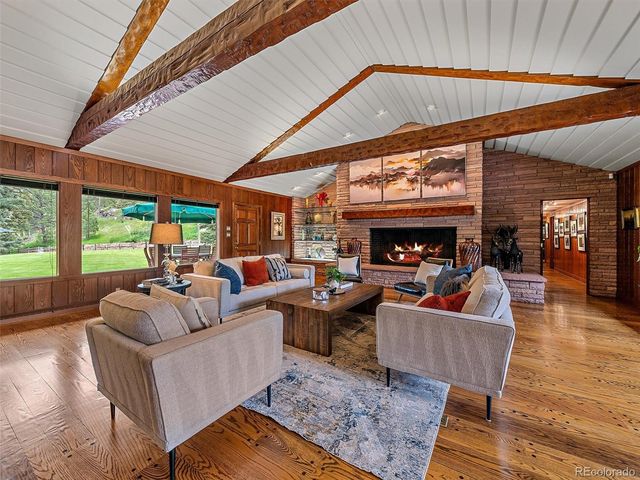 a living room with furniture a fireplace and a large window