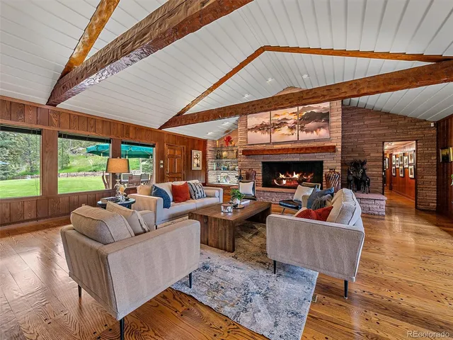 a living room with furniture a fireplace and a large window
