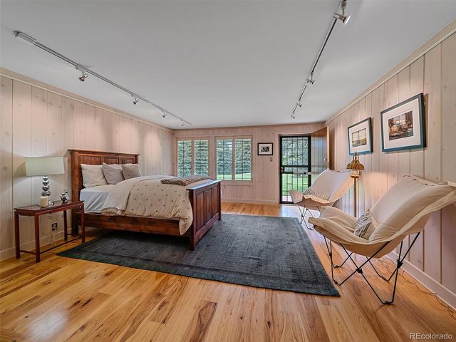 a spacious bedroom with a bed a table and large windows