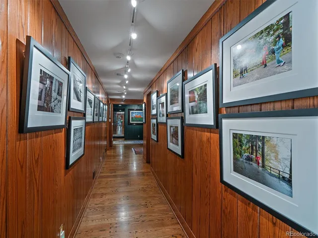 a hallway with wooden floor fireplace and furniture