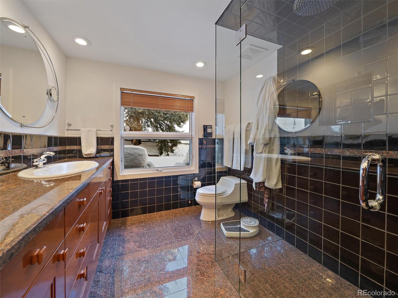 32453 Upper Bear Creek Road Evergreen, CO 80439 - Photo 30 of 48 a bathroom with a toilet a sink a mirror and bathtub