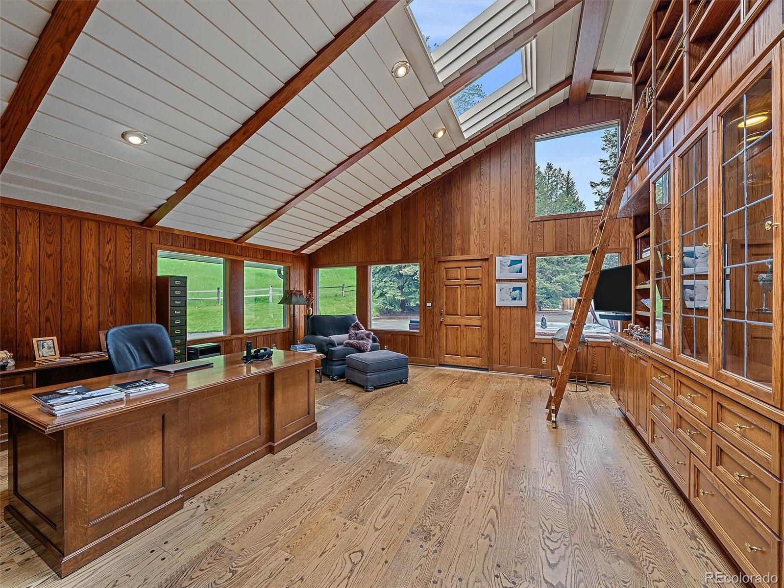 32453 Upper Bear Creek Road Evergreen, CO 80439 - Photo 34 of 48 a view of a patio with table and chairs barbeque with wooden floor and fence