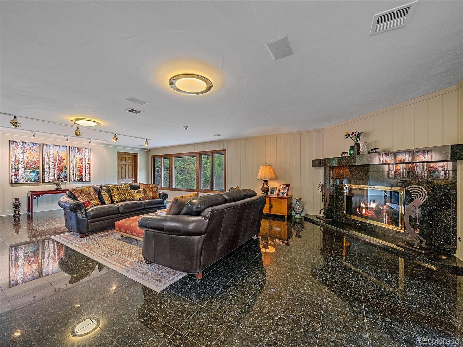 32453 Upper Bear Creek Road Evergreen, CO 80439 - Photo 44 of 48 a living room with furniture and a fireplace