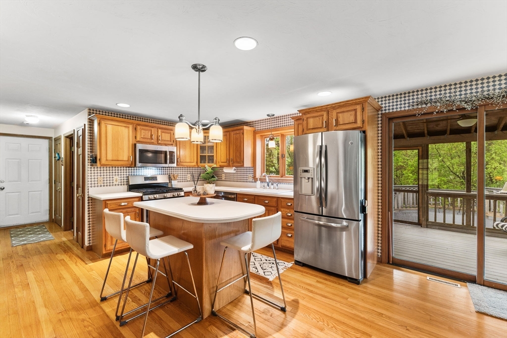 2 McTee Drive Norton, MA 02766 - Photo 4 of 42 a kitchen with stainless steel appliances a dining table chairs refrigerator and cabinets