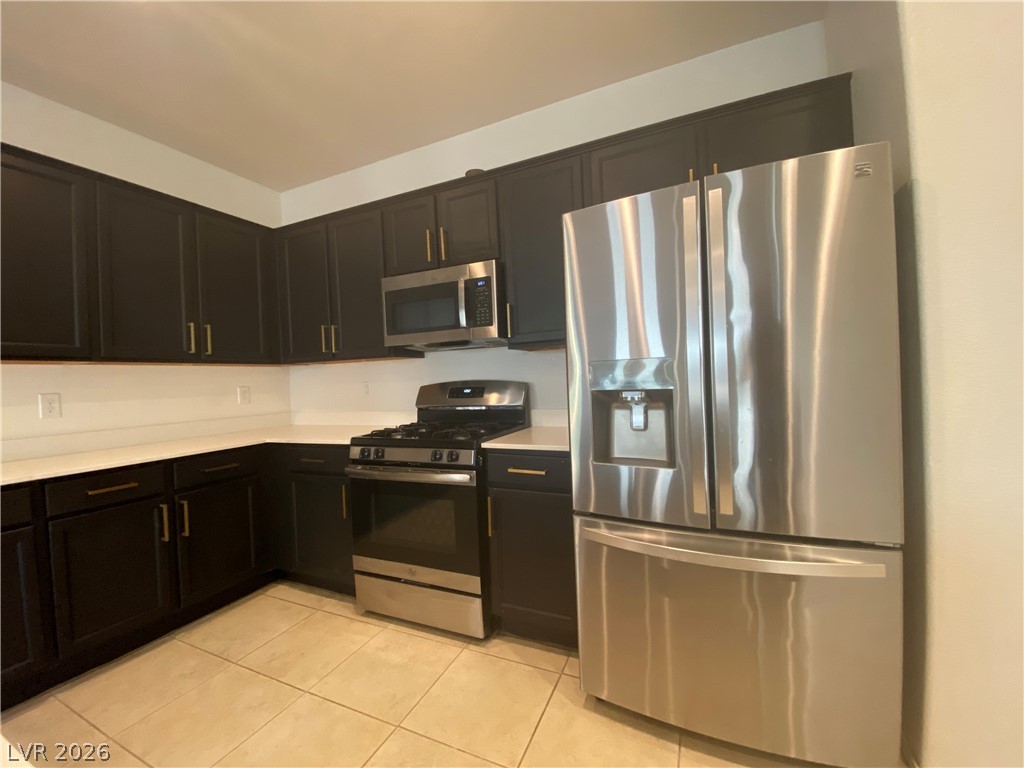 436 Cadence View Way Henderson, NV 89011 - Photo 3 of 36 A well-appointed kitchen showcasing contemporary dark cabinetry and lustrous stainless steel appliances.