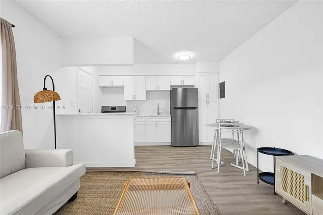 a kitchen with a refrigerator sink and cabinets