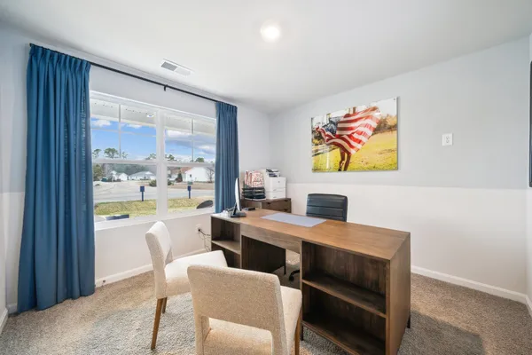 a view of a dining room with furniture a rug and a large window