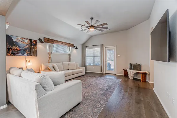 a kitchen with stainless steel appliances kitchen island granite countertop a dining table chairs and white cabinets