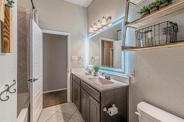 a bathroom with a double vanity sink mirror and bathtub