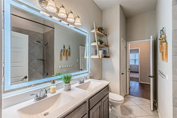 a bathroom with a sink a toilet and mirror