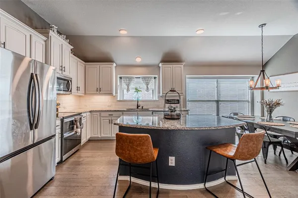 a kitchen with granite countertop stainless steel appliances a sink a counter top space cabinets and a window